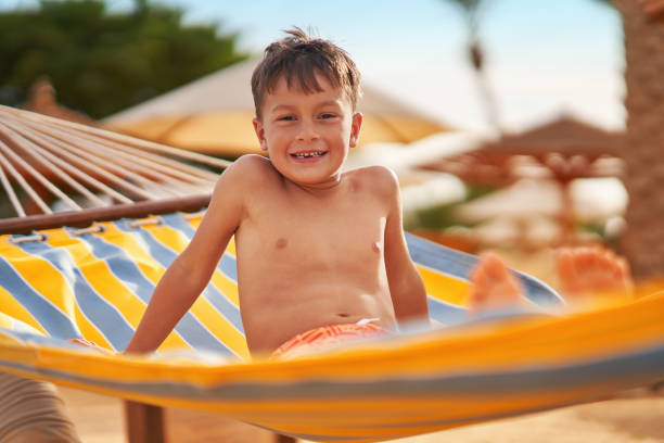 istock Happy boy kid on hammock on the beach Hurghada Egypt 2193094320