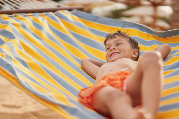 istock Happy boy kid on hammock on the beach Hurghada Egypt 2193094485