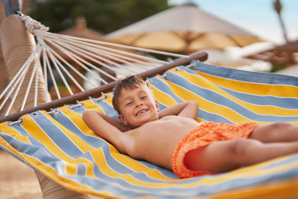 istock Happy boy kid on hammock on the beach Hurghada Egypt 2193094683