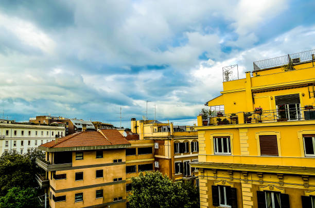 The sky is cloudy and the sun is not visible. There is a yellow building in the background