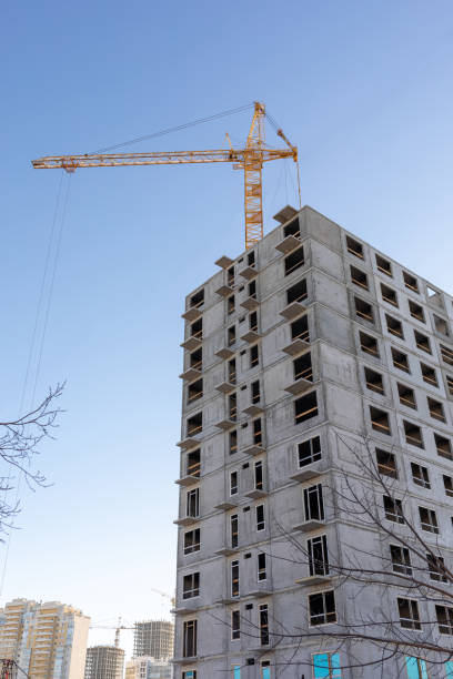 istock Tower cranes next to a multistory panel building under construction in the city, vertical photo. 2193098038