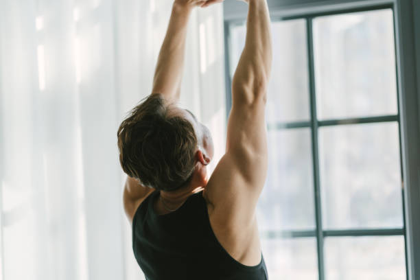 istock A man is stretching his arms in front of a window 2193098183