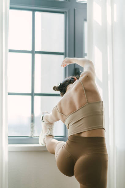 istock A woman is stretching in front of a window 2193098242