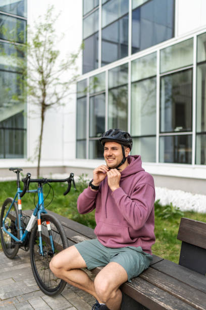 istock Young handsome cyclist putting on his protective hemlet 2193101233