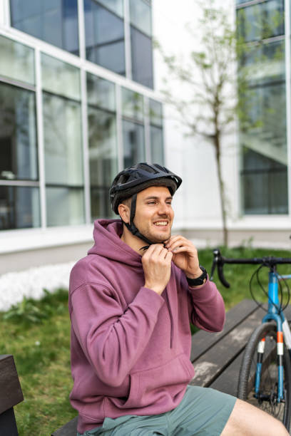 istock Young handsome cyclist putting on his protective hemlet 2193101258