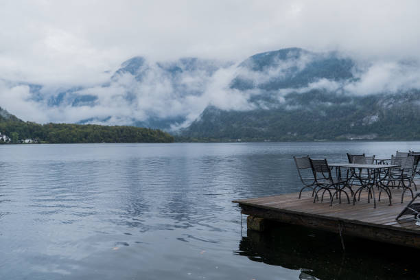 A picturesque Hallstatt lakeside between the stunning mountains and gentle misty clouds above, Austria