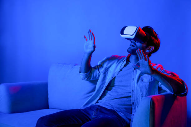 istock Scared person watching at horror movie by using VR goggles at sofa. Deviation. 2193108369