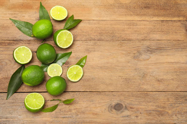 istock Fresh limes and leaves on wooden table, flat lay. Space for text 2193109462
