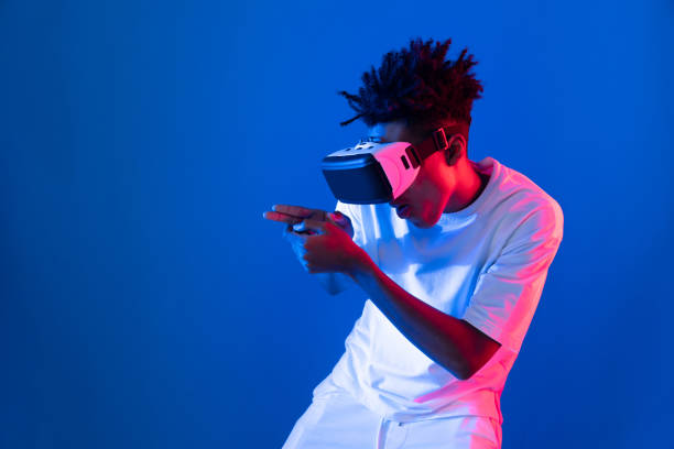 istock Young African American player using VR turn hunter game neon wall. Contrivance. 2193109876