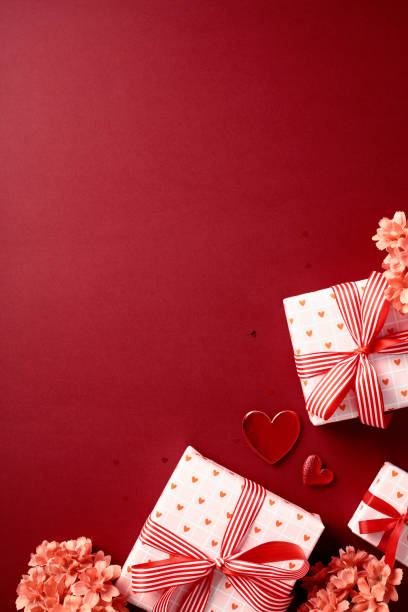 istock Valentine's day gifts on rich red background. Vertical banner design with present boxes and flowers. 2193111922