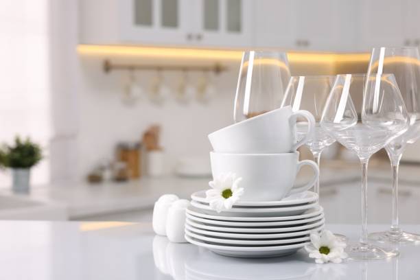 istock Set of clean dishware, glasses and flowers on table in kitchen, space for text 2193112397
