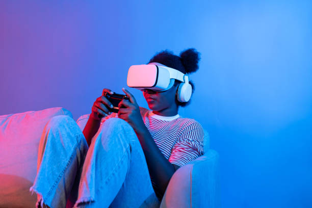 istock Smiling African playing gaming player wearing VR control joystick. Contrivance. 2193114032