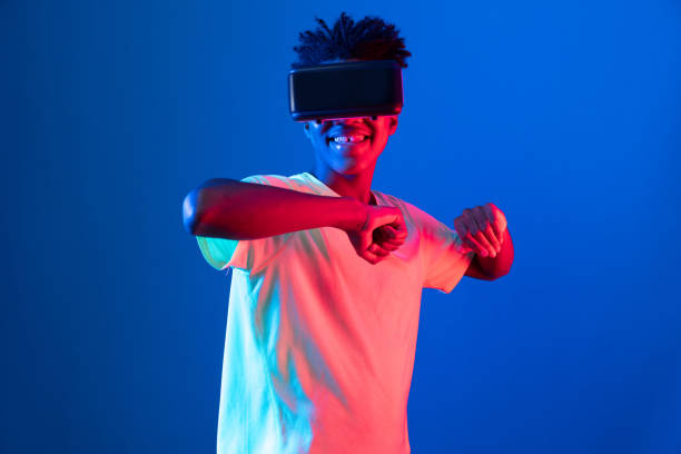 istock African sport player wearing VR stretching arm neon light wall. Contrivance. 2193115162