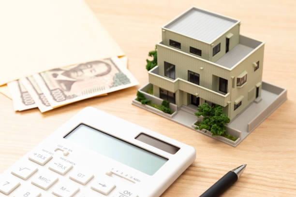 istock A model house, money and a calculator. 2193115557