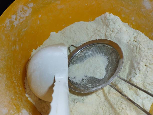 istock A plastic scoop and a sieve for sifting lie in a yellow plastic container with white wheat flour. Cooking theme. 2193117016