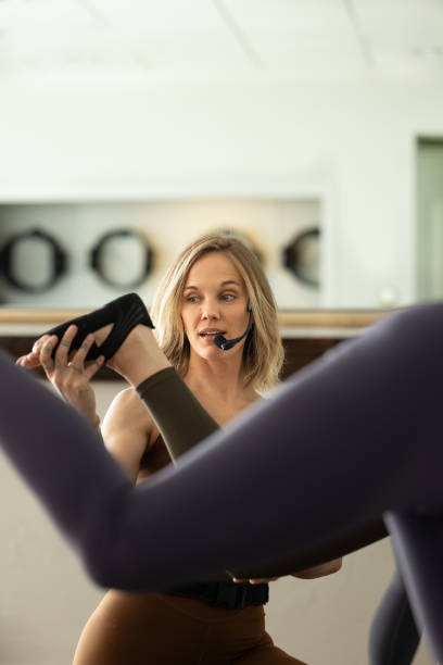 istock Yound Adult Woman Leading Group Exercise Class, Correcting Form, Working Out 2193117246