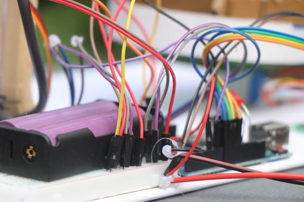 istock Set of jumper cables connected to micro controller and breadboard with a battery as part of electronics project prototyping 2193123767