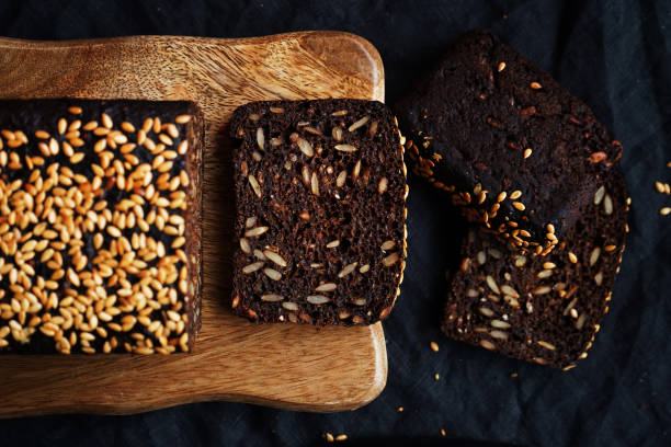 istock Brown bread with grains and sesame on a wooden board on a dark background 2193137440