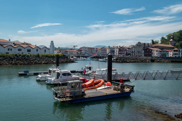 View over the port of Saint Jean de Luz with several boats anchored at the pier and some of the traditional Basque architecture in the background in France