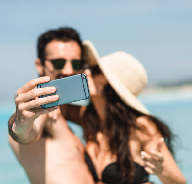 istock couple take a selfie on the beach in summer 2193138341