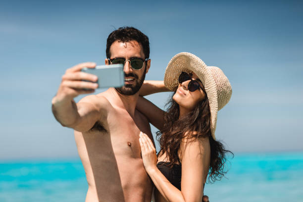 istock couple take a selfie on the beach in summer 2193138428