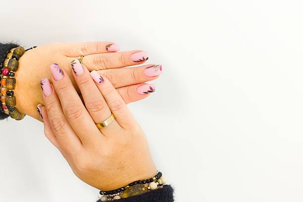istock Stunning pink nails with shimmering leaves, complemented by gold accessories and gemstone bracelets. 2193140607