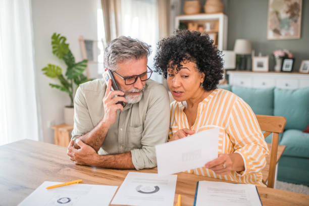 istock Multi-ethnic woman sitting next to her husband making a phone call with a customer support representative 2193143045