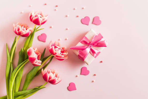 istock Pink tulips and hearts, gift box with ribbon on light pink background 2193148567