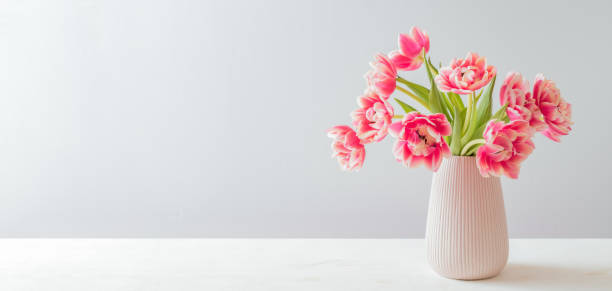 istock Pink tulips in a vase on a white table 2193148572