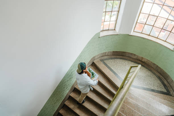 Photo of a young Asian man is carrying things with a clear box into a new apartment