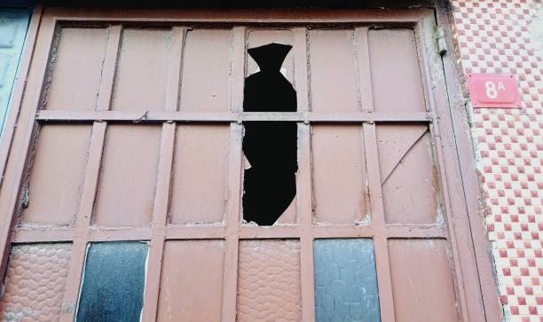 istock Old brown iron door. Broken glass in the door. 2193149917
