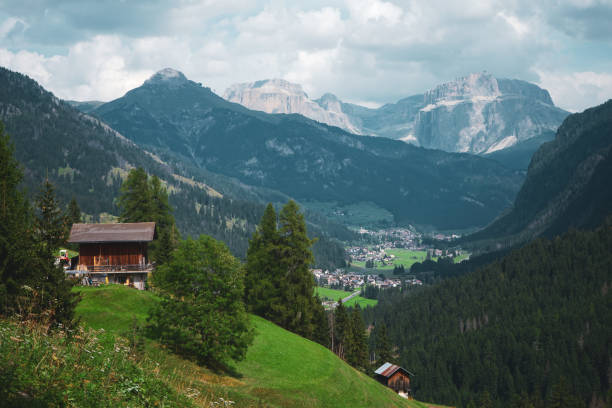 Moody sky over mountains and village in summer, Dolomites