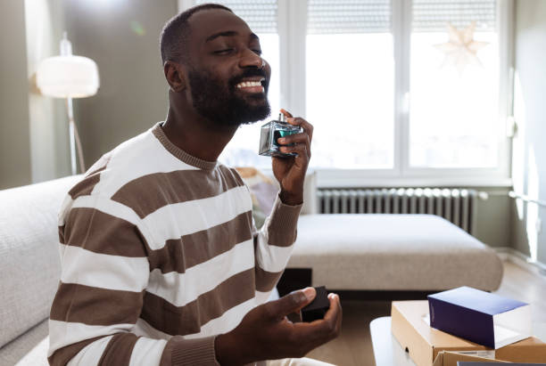 istock Man joyfully applying new cologne in a bright and stylish home interior 2193152453