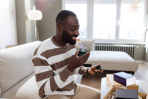 istock Man unboxing and enjoying a perfume in a cozy living room setting 2193152455