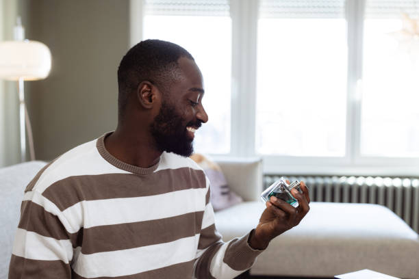 istock Smiling man looking at a new fragrance at home 2193152484