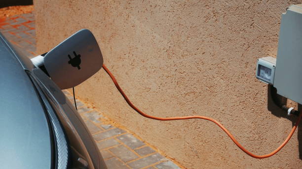 istock Car Electric Charging Closeup Modern Silver Orange Cable Technology Power 2193153358