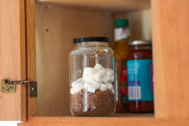 A jar of brown sugar inside of a kitchen cabinet with marshmallows to keep it fresh