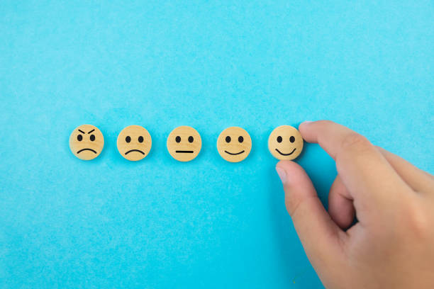 istock Concepts of customer service evaluation and satisfaction survey. Client's hand selected happy smile face icon on wooden cube on blue background. copy space 2193154941