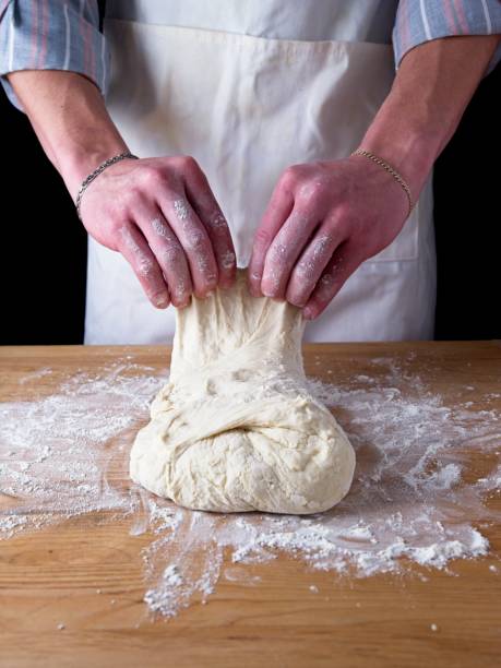 Folding dough on a table.