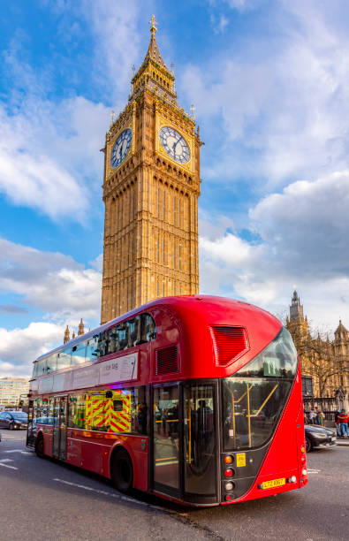 London, United Kingdom - April 19, 2025: A picture of the iconic red double-decker buses driving on the Westminster Bridge and in front of Big Ben.