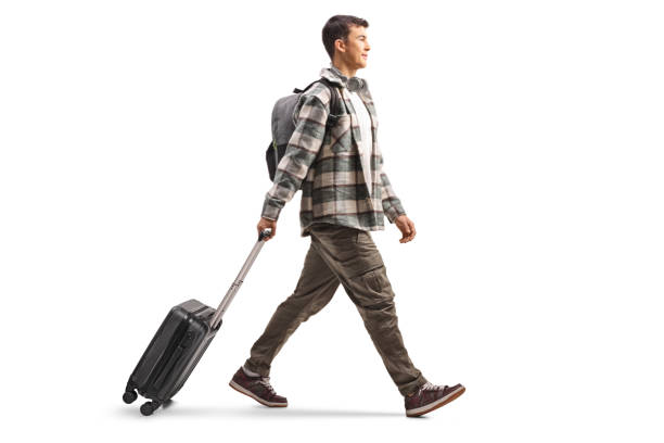 istock Full length profile shot of a student pulling a suitcase and walking 2193160428