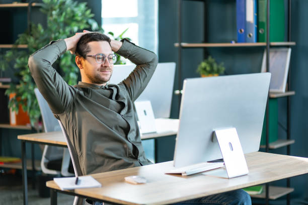 istock Caucasian businessman sitting at table in cafe modern cozy office looking at computer screen feels satisfied proud with done work, serene man resting putting hands behind head relaxing no stress concept 2193161341