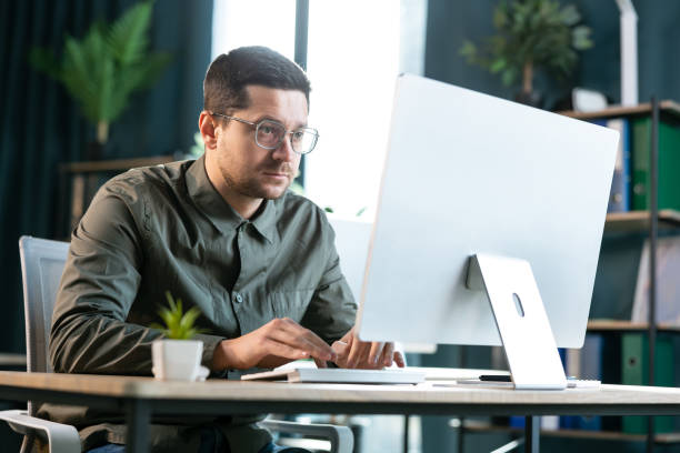 istock Business man wearing glasses working with a desktop computer at office 2193161355