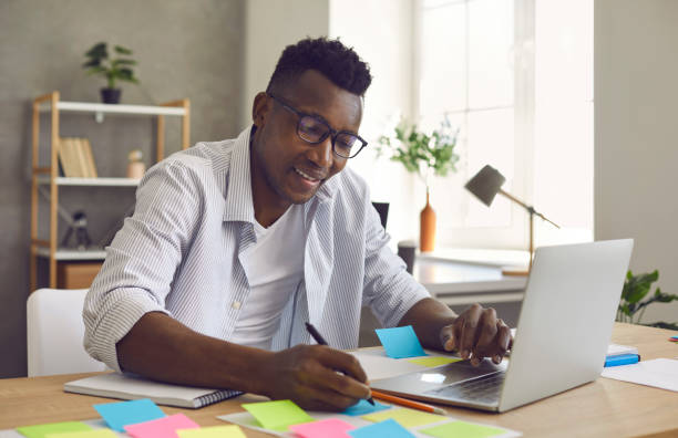 istock African American man writes notes on stickers while developing a business project in the office. 2193164089