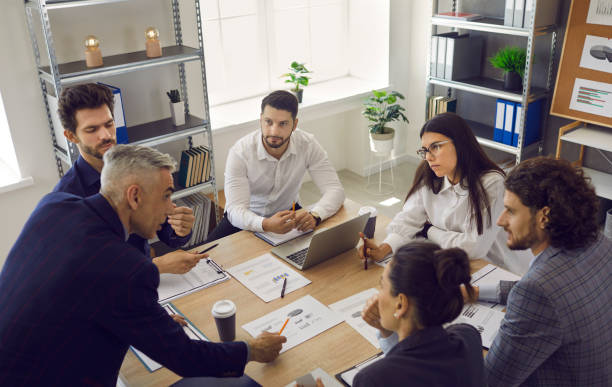 istock Senior employee makes business development suggestions to his colleagues sitting at the table. 2193165939