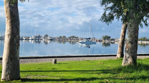 istock A sailboat is moored in a calm harbor surrounded by trees 2193167611