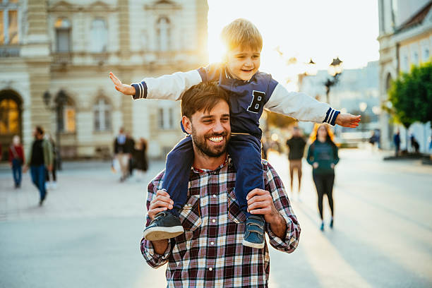 istock Father carrying his young son on shoulders, both smiling joyfully in bright urban setting during golden hour 2193168710