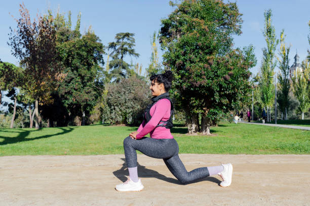 Young sportswoman stretching legs before running in a park