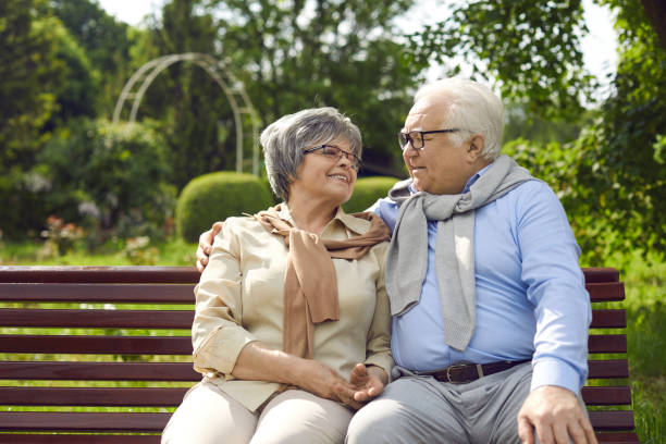 istock Happy loving senior couple sitting on bench and hugging looking into eyes 2193172756