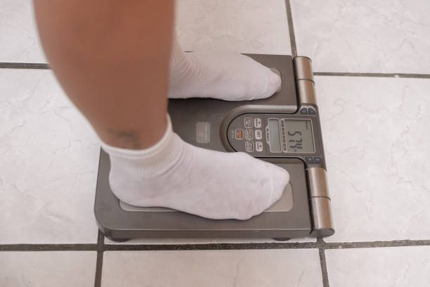 istock Female feet on a weighing scale. Body weight control concept. 2193174571